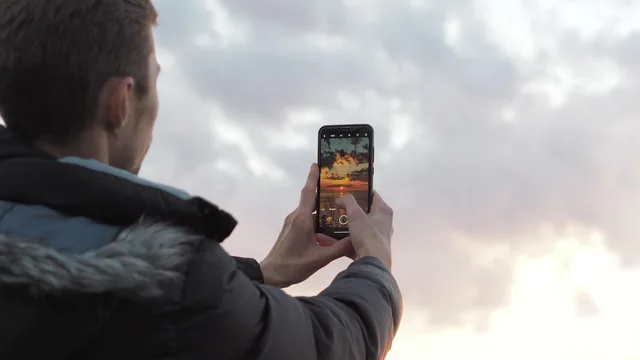 smartphone, photography, sunset, phone, mobile phone, phone camera, screen, device, man, person, taking photo, sea, ocean, sky, clouds, nature, twilight, dusk, evening. How three kinds of adoption reshape a social media format