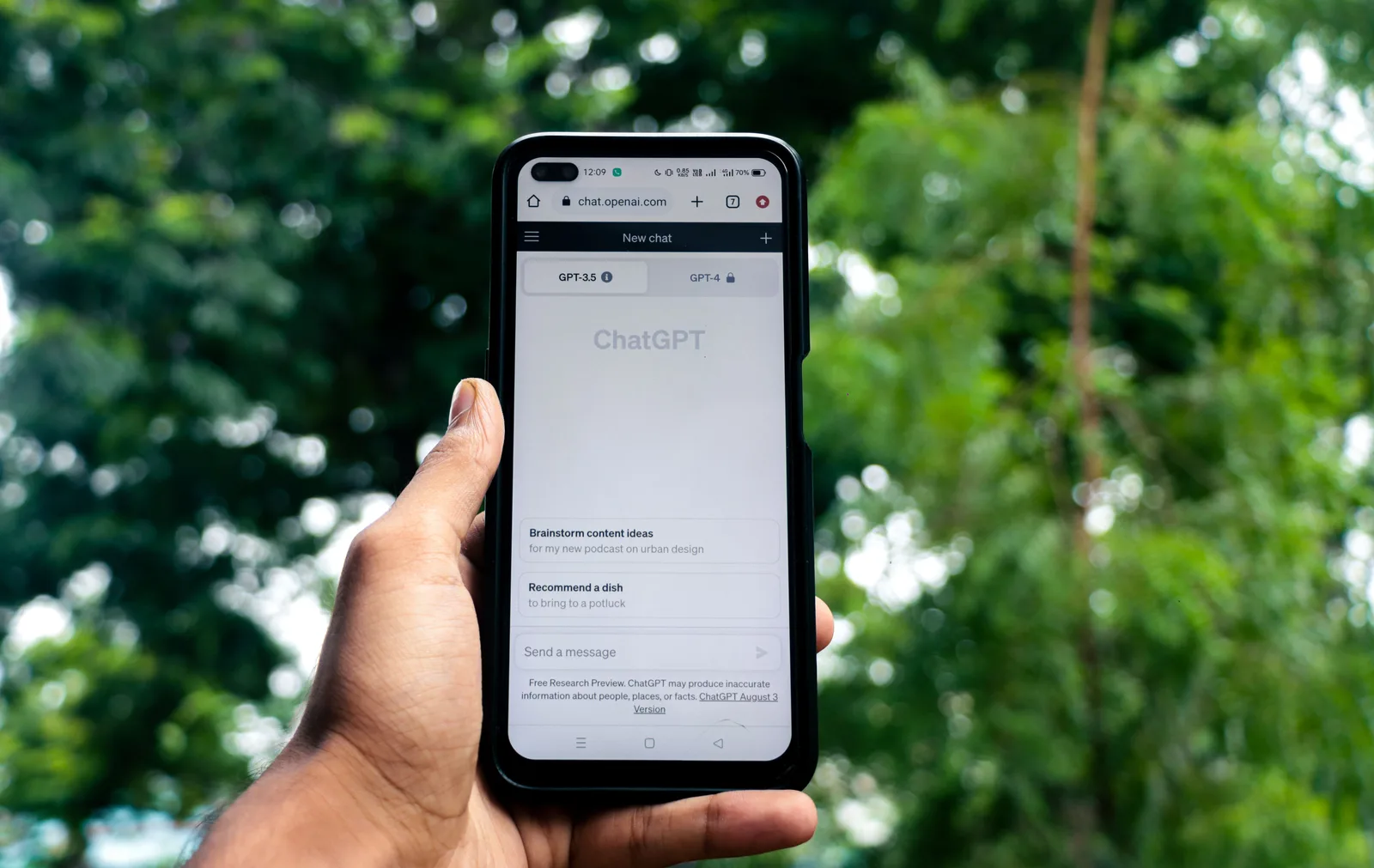 Close-up of a hand holding a smartphone displaying ChatGPT outdoors. Is dead internet theory supported by US platform data?