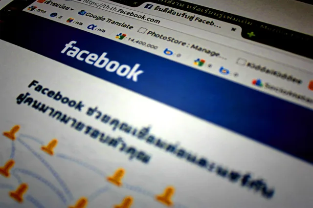 High-angle shot of the Facebook website homepage displayed on a computer screen in Thai language. Early social networks guide: reading old pages
