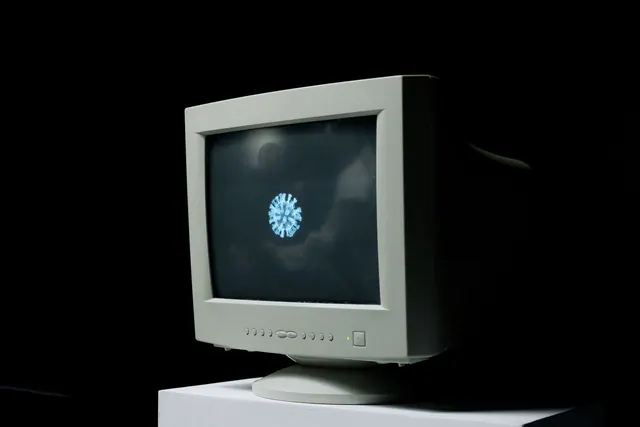 A vintage computer monitor shows an image of a coronavirus on screen against a dark background. Memes and virality: methods, tools and useful context